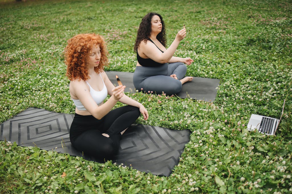 Women Holding Burning Dried Leaves While Sitting on a Yoga Mat